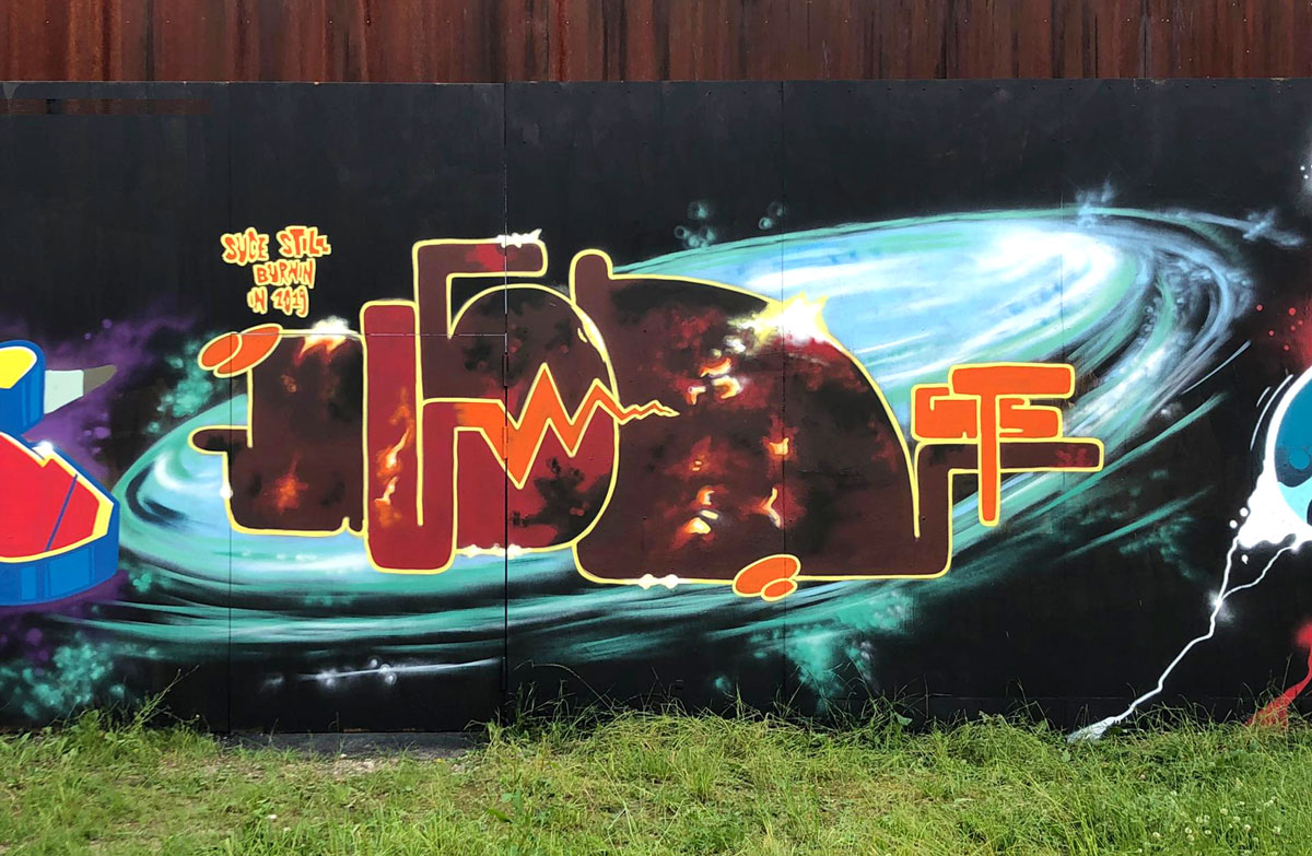 Orange-brauner Schriftzug, im Hintergrund eine Galaxie