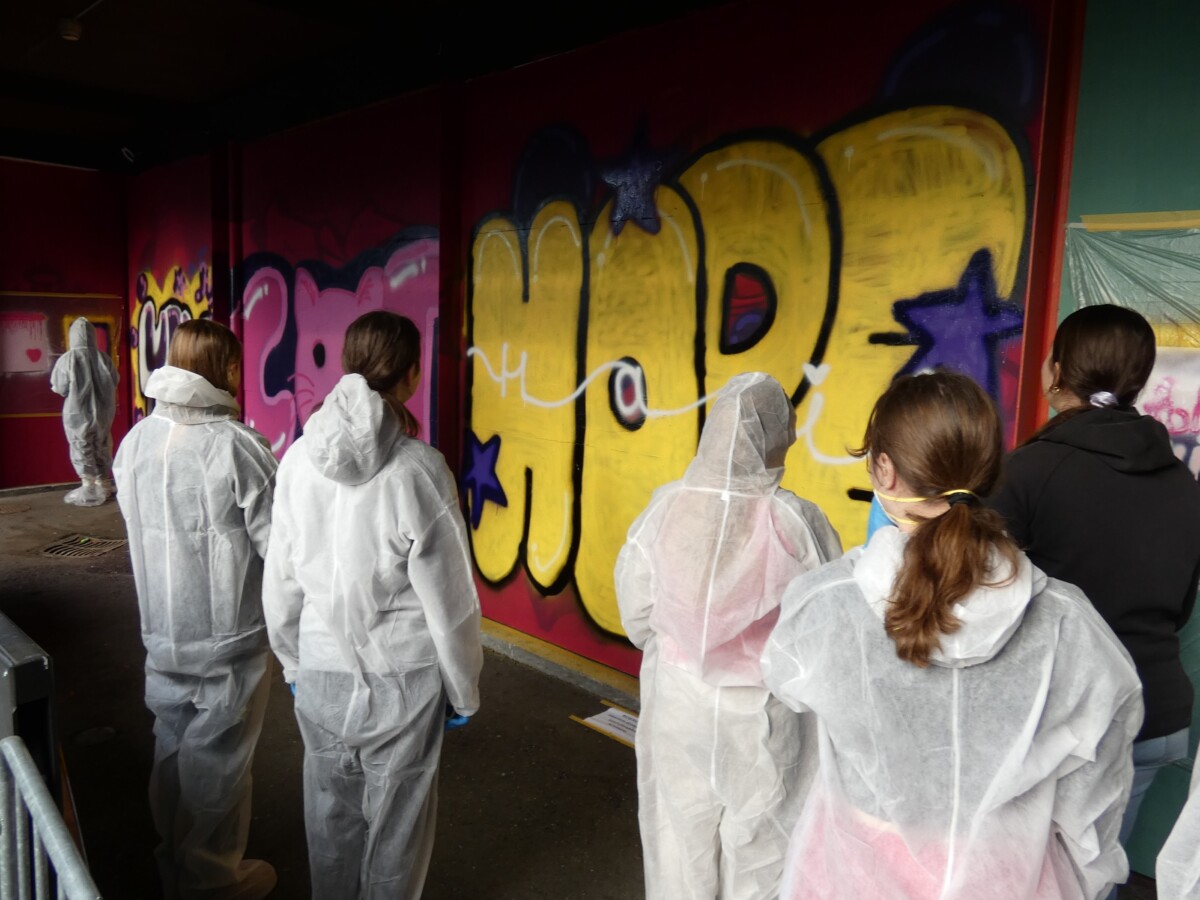 Jugendliche stehen vor einem Graffiti